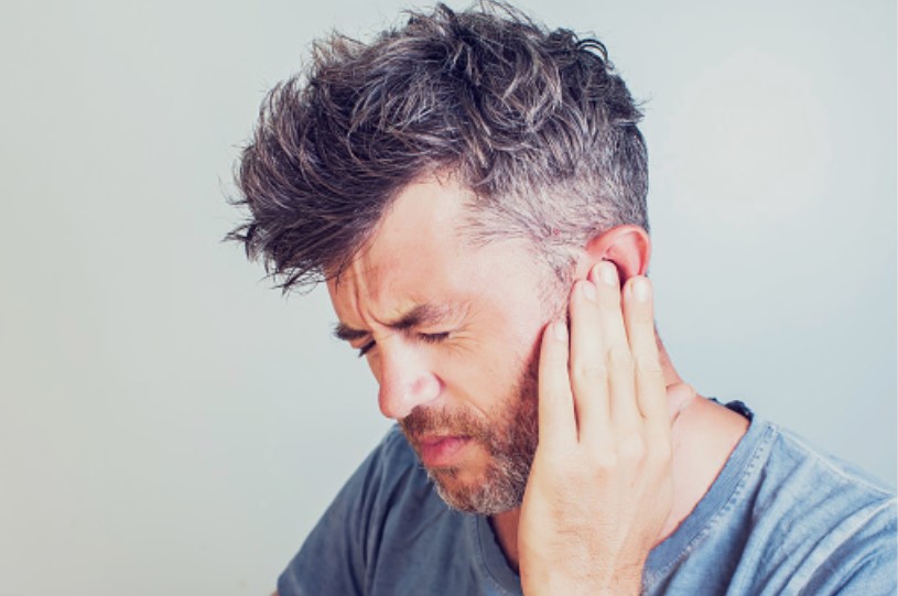 Picture of a man experiencing crackling in the ear