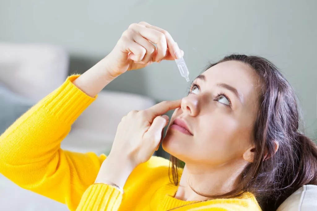 Young woman uses eye drops for eye treatment. Redness, Dry Eyes, Allergy and Eye Itching