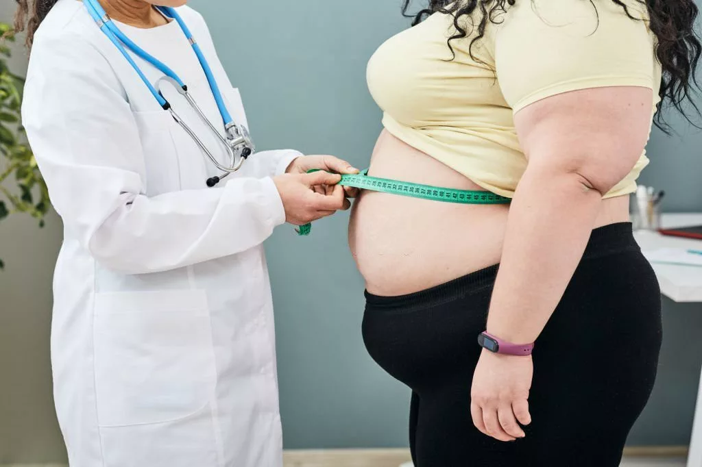 Image of a medic measuring waist circumference of a patient