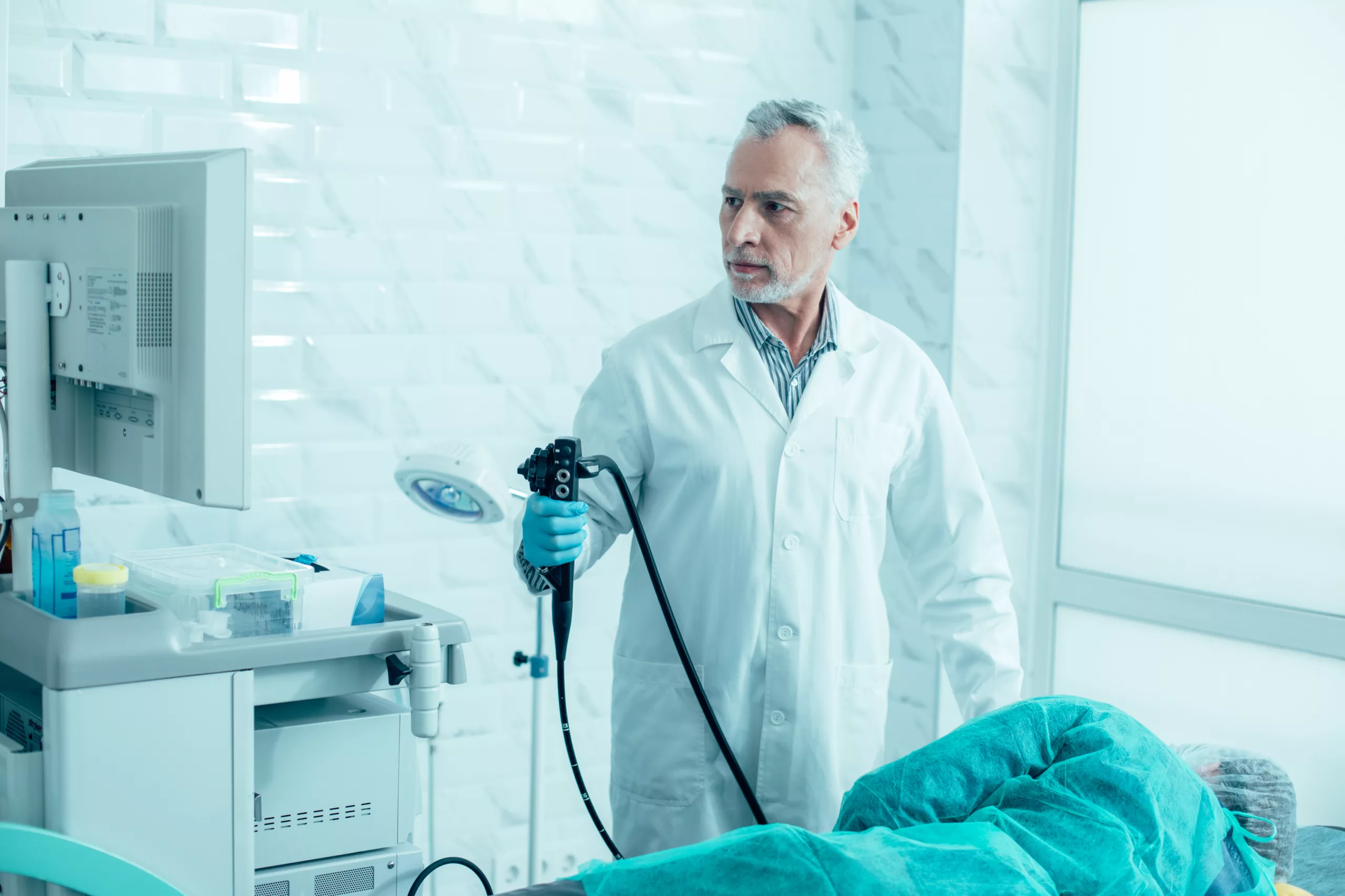 A doctor holding a bronchoscope and preparing for the procedure