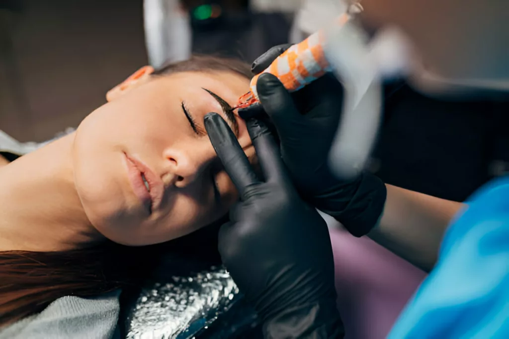 Image showing eyebrow microblading using pen style tool with small needles attached at the end 